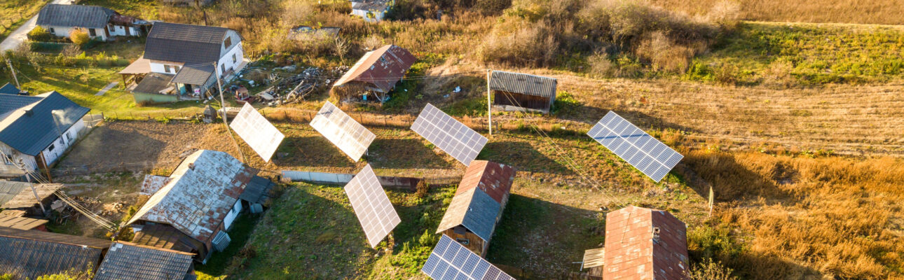 Aerial top down view of solar photo voltaic panels in green rural area. Clean renewable energy in private village environment.